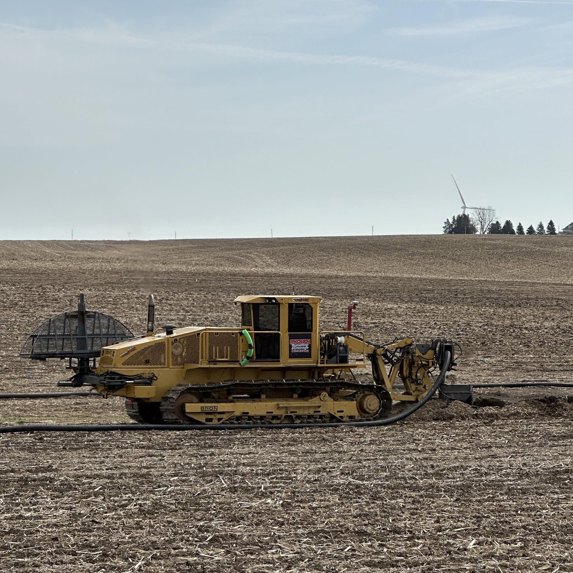 Yellow BRON tiling plow installing perforated drainage pipe in an Iowa farm field Yellow BRON tiling plow installing perforated drainage pipe in an Iowa farm field